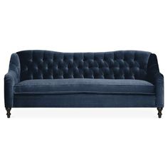 a blue velvet couch with black legs and buttons on the back, viewed from the front