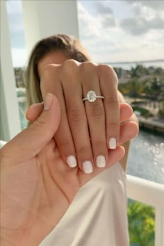 a woman holding her hand up to the camera with a ring on it's finger