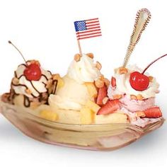 two scoops of ice cream with strawberries and an american flag on top