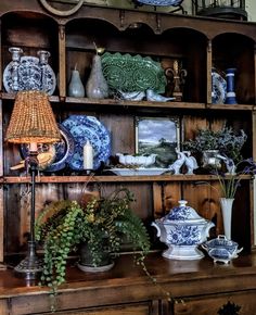 an old china cabinet filled with blue and white plates, vases and other decorative items