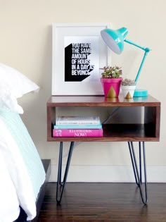 a nightstand with some books and a lamp on it