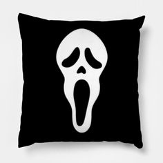 a black and white pillow with a ghost face on it's side, in the shape of a scream