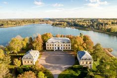 an aerial view of a large mansion in the middle of a lake surrounded by trees