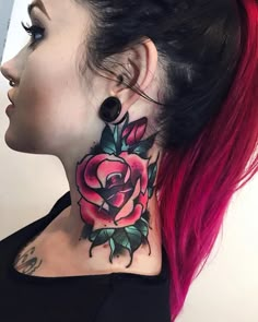 a woman with pink hair has a rose tattoo on her neck and behind her ear