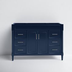 a blue cabinet with two doors and three drawers on the bottom, against a white wall