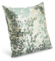 a green and white pillow on a white background