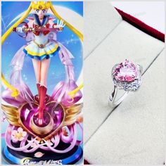 a pink diamond ring sitting on top of a table next to an image of sailor moon