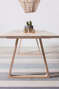 a wooden table sitting on top of a carpeted floor next to a light fixture