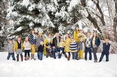 a group of people standing next to each other in front of a snow covered tree