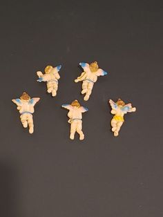 five little angel figurines sitting next to each other on a black table top