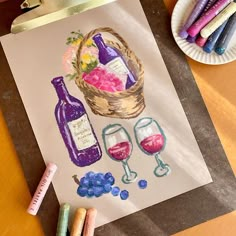 a paper plate with some crayons and wine bottles next to it on a table