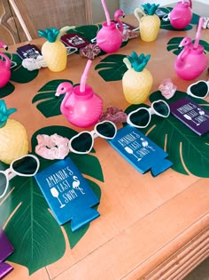 the table is decorated with pineapples, flamingos and sunglasses for an aloha