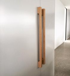 a door handle on the side of a white wall in an empty room with concrete flooring