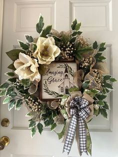 a wreath is hanging on the front door with flowers and greenery around it that says imagine grace