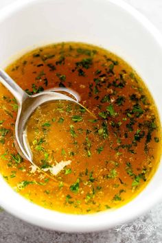 a white bowl filled with soup and garnished with parsley on the side