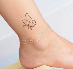 a small tattoo on the ankle of a woman's foot, depicting a butterfly