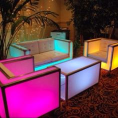 several lit up couches and tables in a room