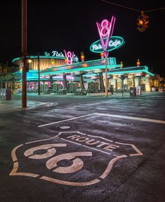 an old route 66 sign is painted on the asphalt in front of a gas station