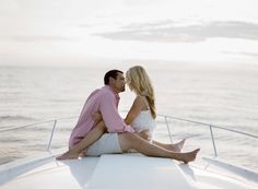 a man and woman sitting on the back of a boat looking into each other's eyes