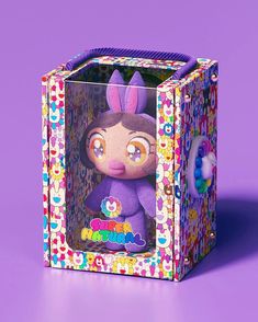 an animal toy in a colorful box on a purple background