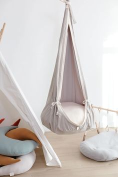 two hammocks with pillows on the floor next to each other