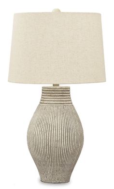 a table lamp with a beige shade on it and a white linen lampshade