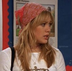 the young woman is wearing a red scarf on her head and she has long blonde hair