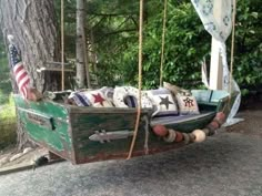 an old wooden boat is hanging from a tree