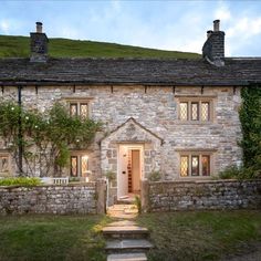 an old stone house with steps leading up to the front door and side entrance area