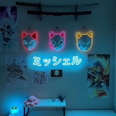 three neon signs are hanging on the wall above a desk with a teddy bear and other items