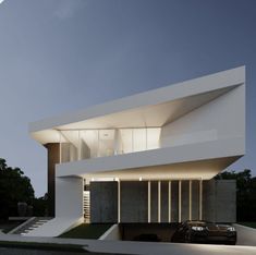 a car is parked in front of a white building with stairs leading up to it