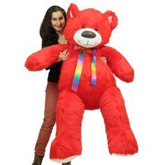 a woman holding a large red teddy bear