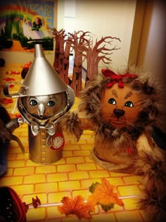 an image of two stuffed animals sitting on the kitchen floor with pumpkin decorations in front of them