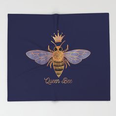 a blue towel with a bee on it and the words queen bee written in gold