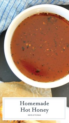 homemade hot honey in a white bowl next to bread on a blue and white towel