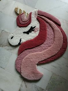 the rug is shaped like a unicorn with a crown on its head