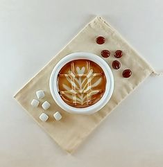 a cup of hot chocolate with marshmallows on a napkin next to it