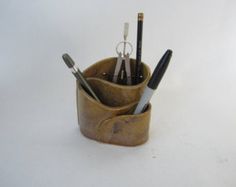 a pen holder with pens and pencils in it