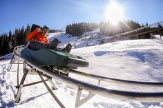 a man riding on the back of a snow covered ski lift