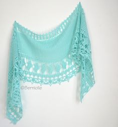 a crocheted shawl hanging on a wall with the top half cut off