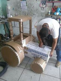 a man working on a cardboard construction vehicle