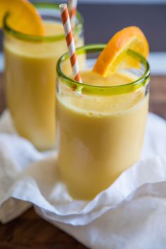 two glasses filled with orange juice on top of a table