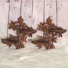 two decorative wooden shelfs sitting next to each other on a white fur covered floor