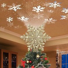 a decorated christmas tree with snowflakes on the ceiling