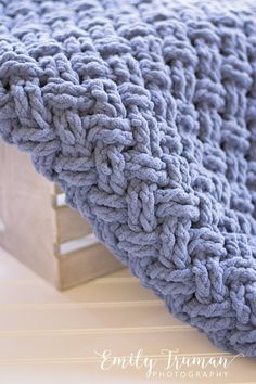 a blue blanket sitting on top of a wooden crate