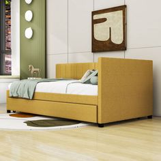 a bed sitting on top of a hard wood floor next to a wall mounted painting