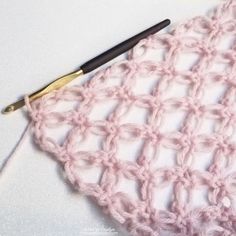 the crochet love knot is being worked on by a person with a pen