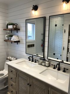 a bathroom with two sinks and three mirrors on the wall next to it is decorated in black and white