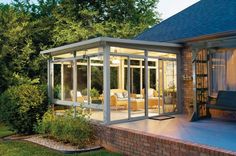 an enclosed patio area with furniture and lighting