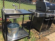 an outdoor bbq grill and sink in the grass